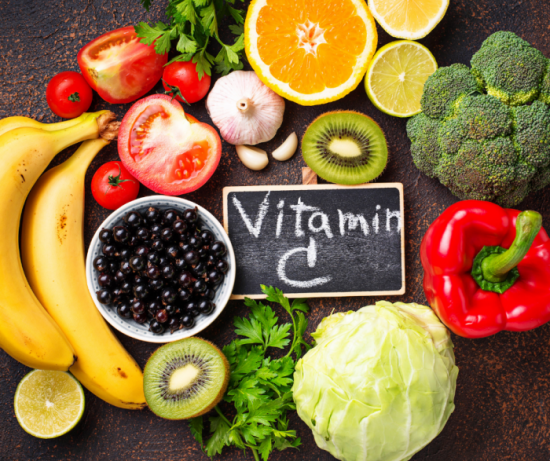 Vitamin C is written in a slate aurrounded by fruits and vegetables which are rich in vitamin c