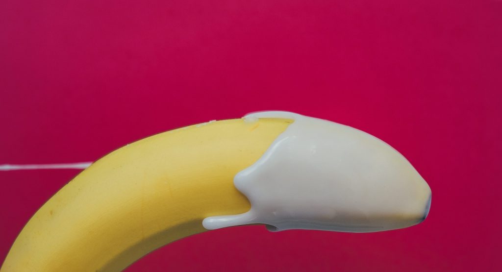 A banana with some cream which is layered on the top which indirectly refers to an premature ejaculation in men