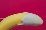 A banana with some cream which is layered on the top which indirectly refers to an premature ejaculation in men