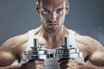 A man holding dumbles up to chest vertically as he is doing exercise for weight loss