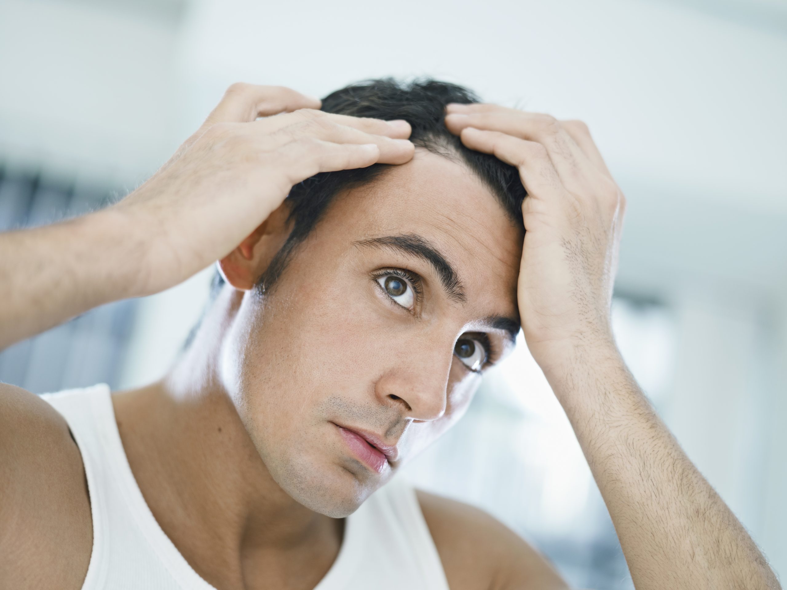 the man checking the scalp for hair loss